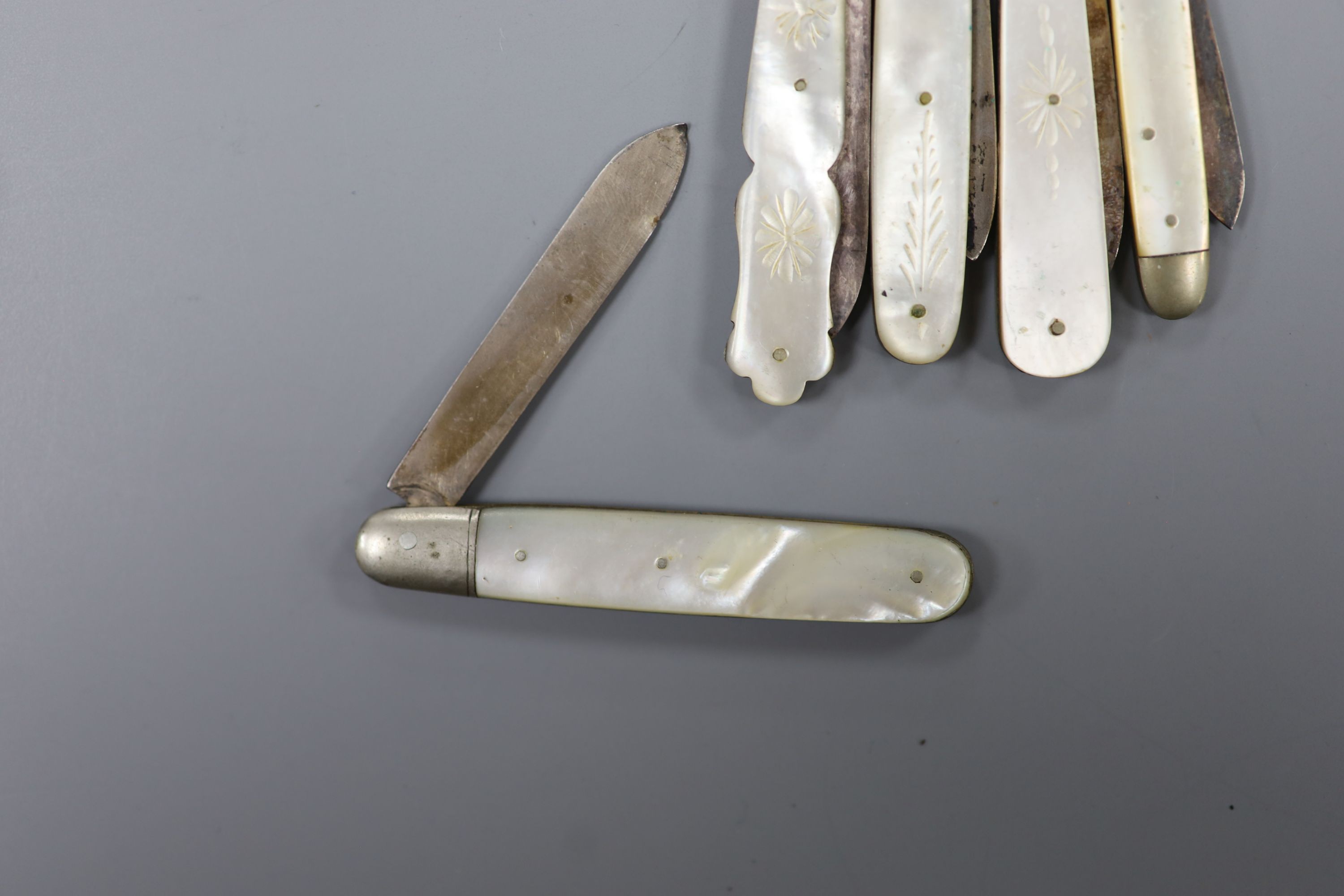 Five assorted early 20th century mother of pearl mounted silver fruit knives and a silver mounted penknife.